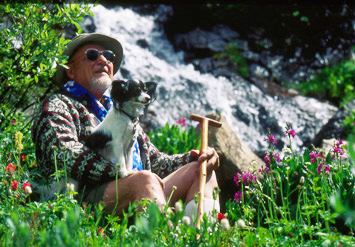 a photo of William A Weber sitting next to a rock with his dog